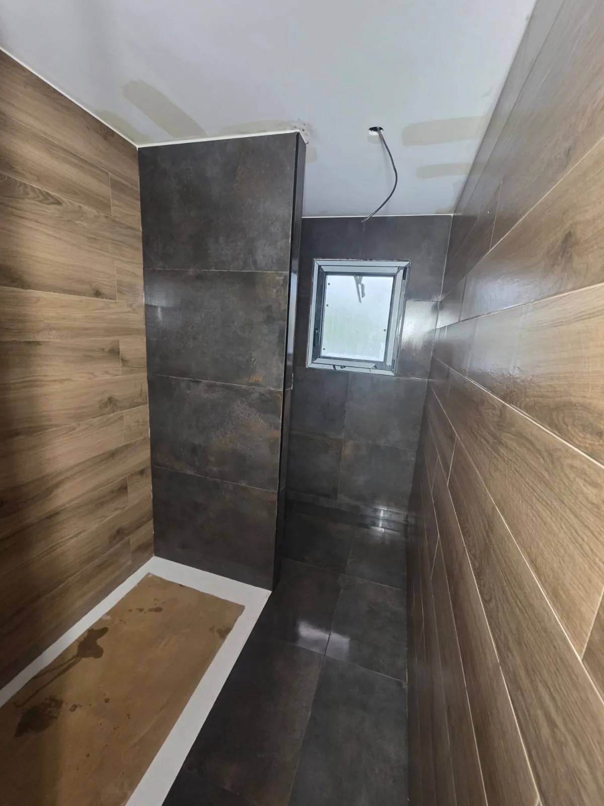 Salle d'eau rénovée, bois et carrelage anthracite